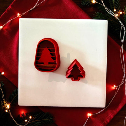 Red arch and tree clay cutters displayed on white tile with red cloth and lights