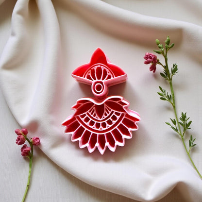 Close-up of red boho fan cutter on cream fabric with tiny pink flowers