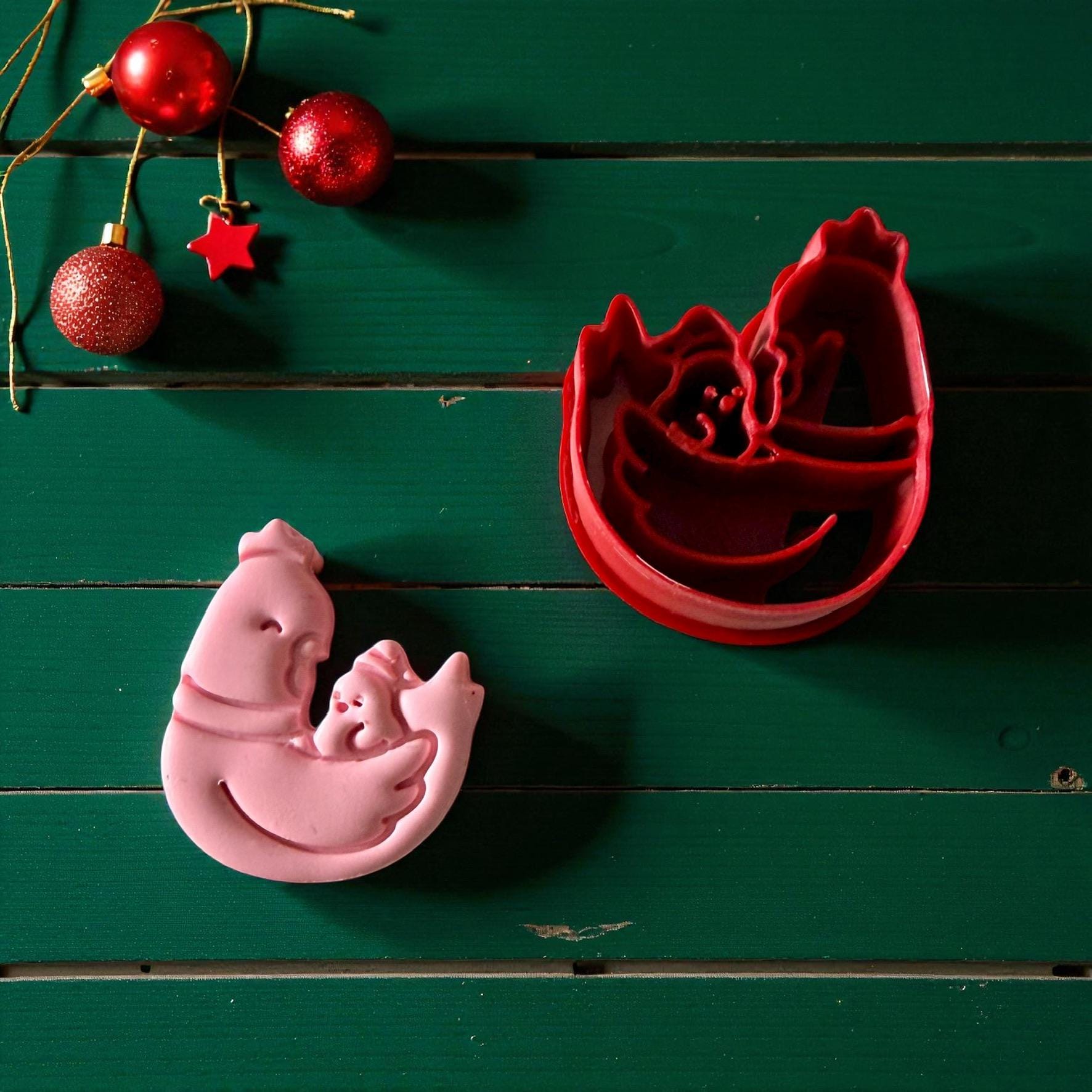 Red chicken cutter and pink clay imprint surrounded by red ornaments