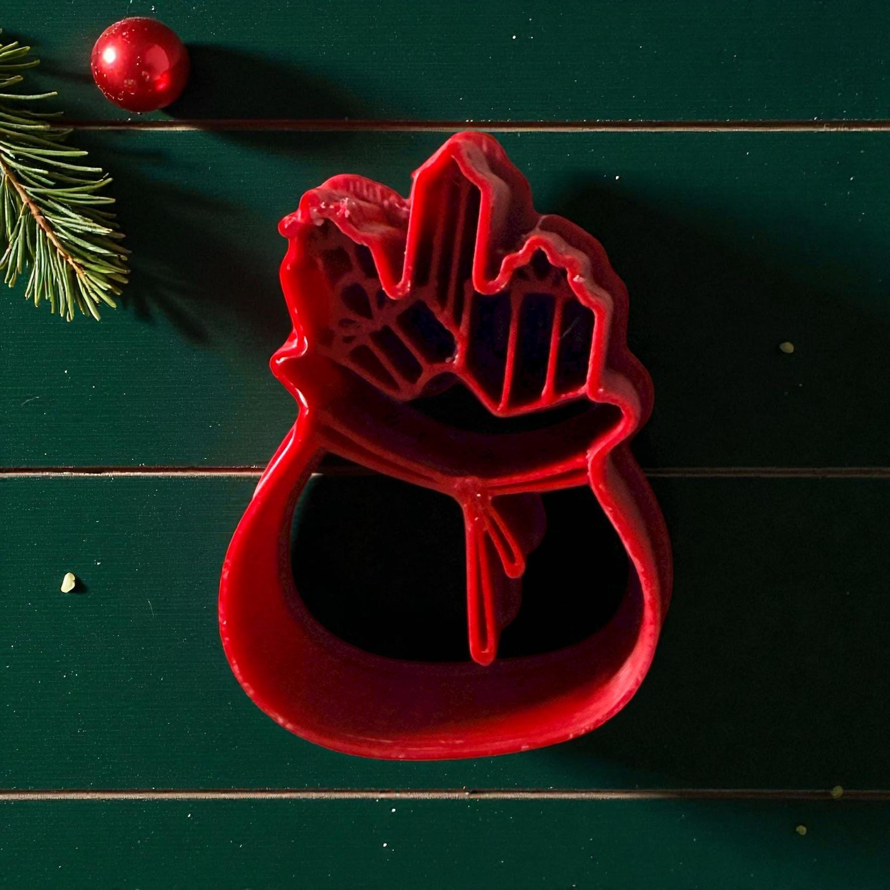 Santa gift bag clay cutter centered on white tile with festive decor