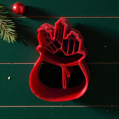 Santa gift bag clay cutter centered on white tile with festive decor