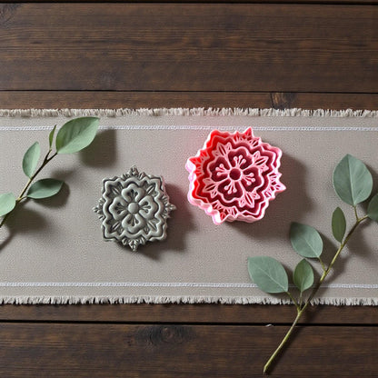 Floral tile-inspired clay cutter beside clay imprint with greenery on linen runner