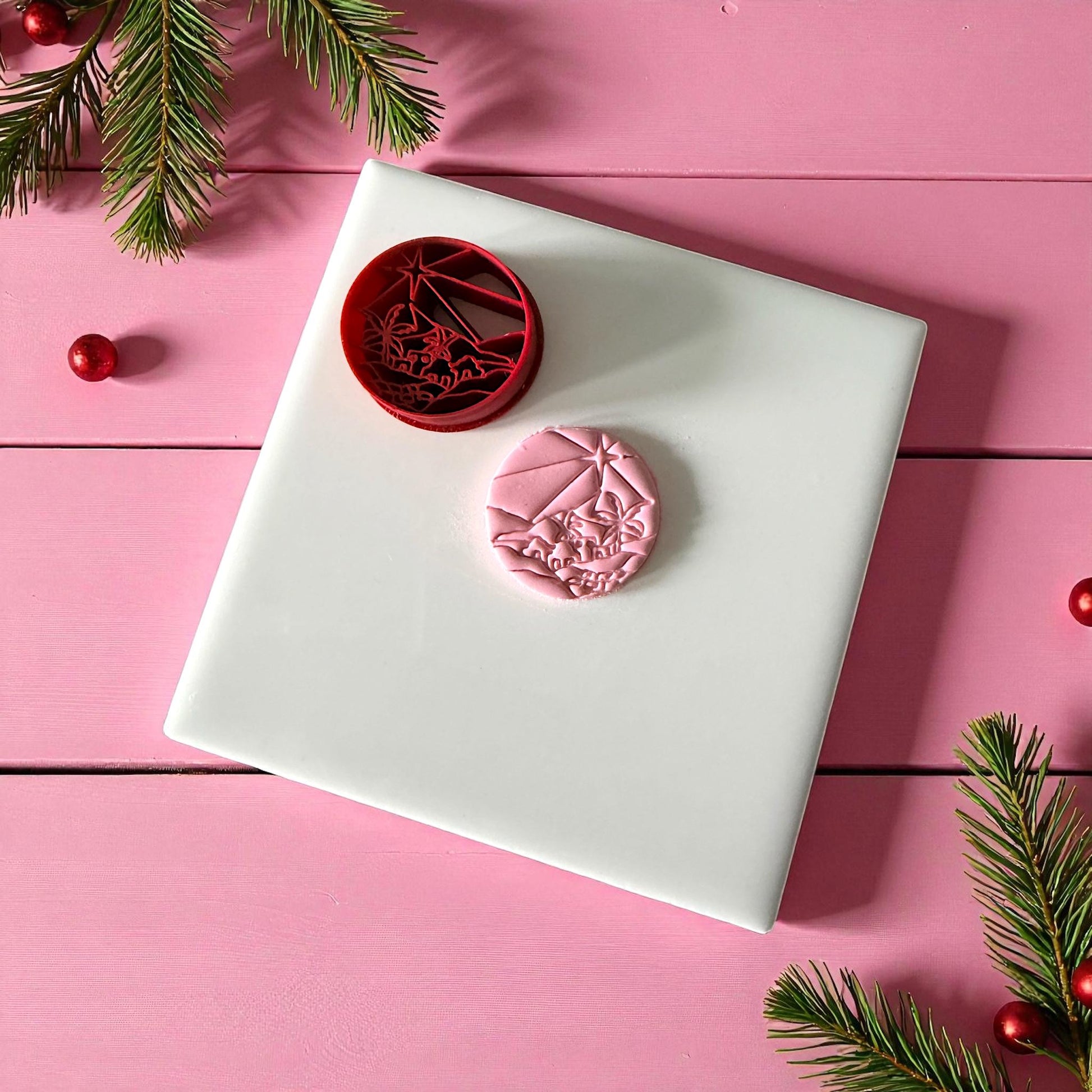 Red cutter and pink clay circle showing Bethlehem star scene on white tile
