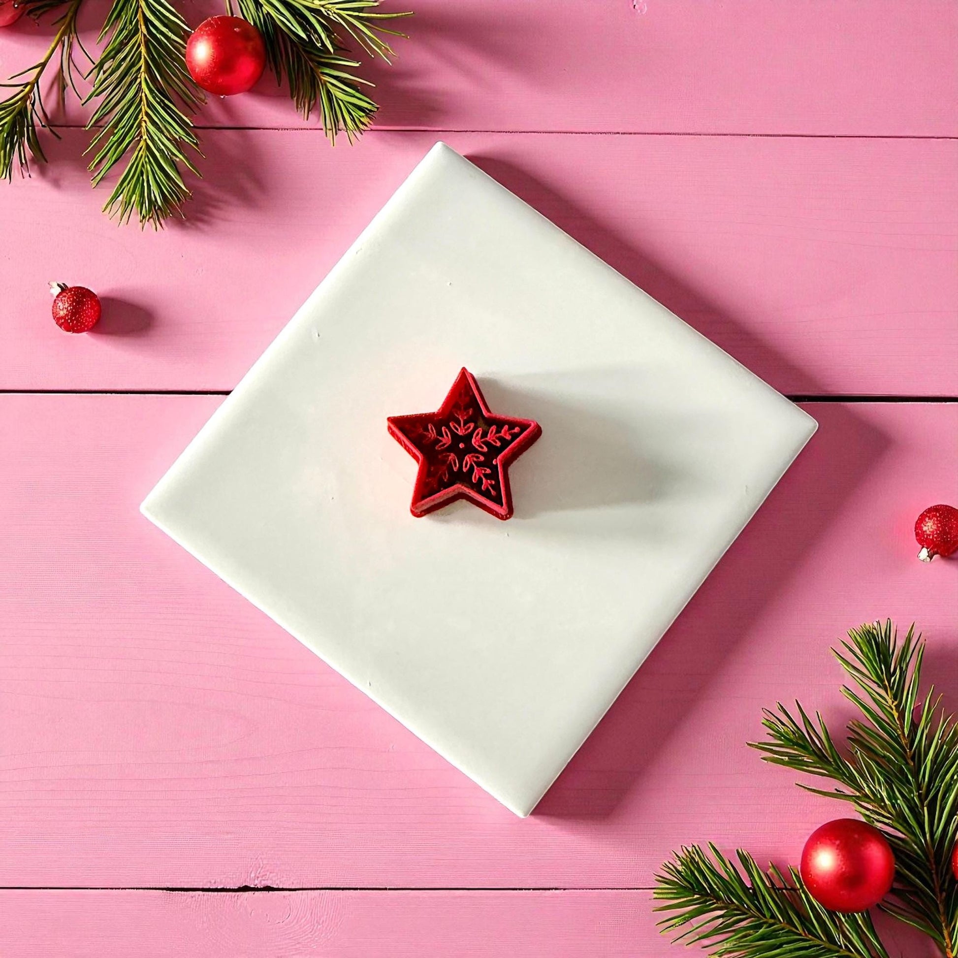Nordic star polymer clay cutter displayed on white tile with pine sprigs