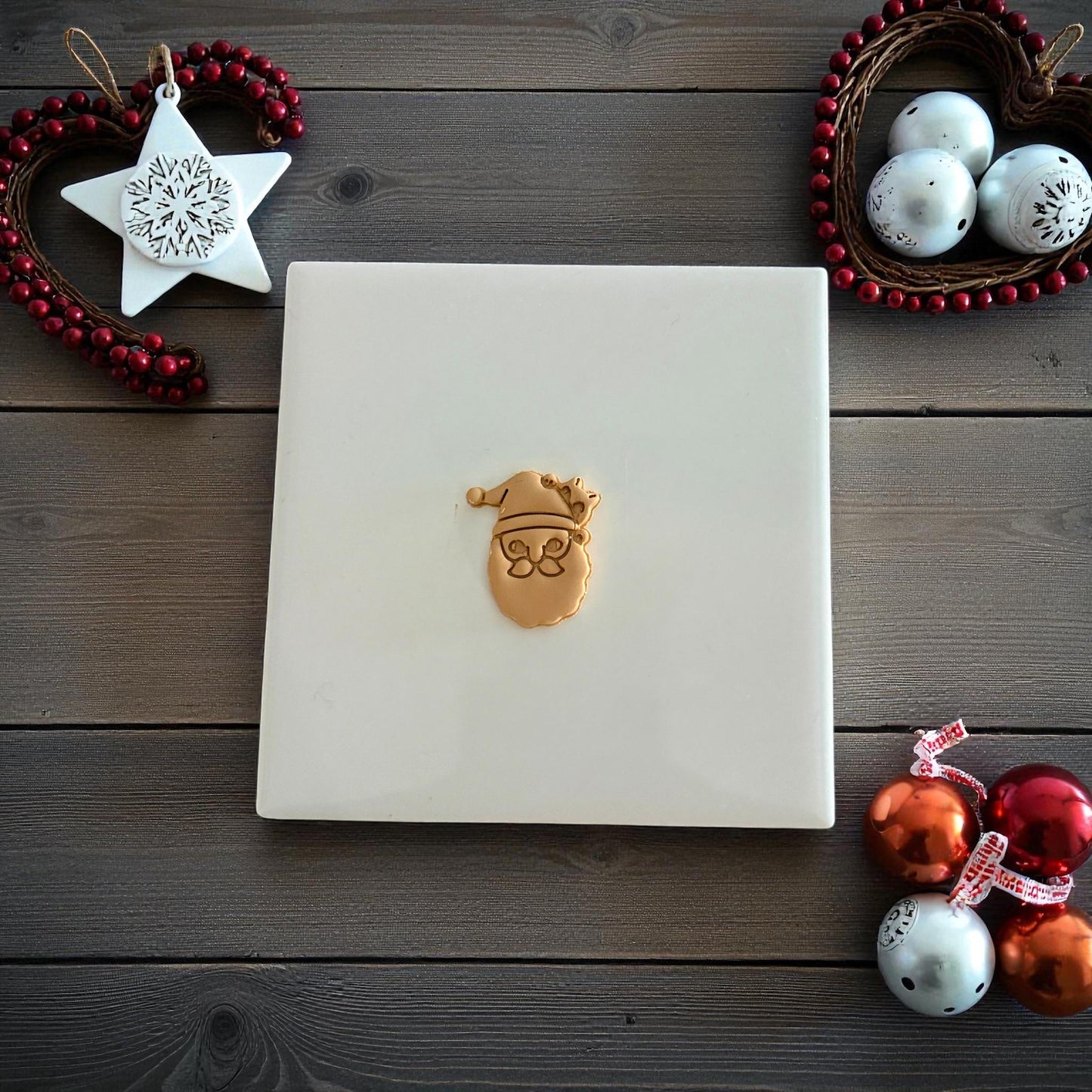 Santa with hidden cat clay imprint on white tile surrounded by festive decor
