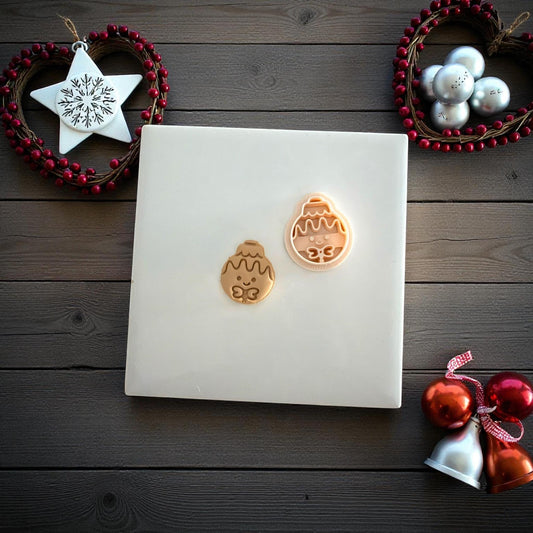 Two gingerbread ornament clay imprints on white tile with festive decor