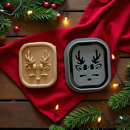Reindeer cutter and clay piece on red napkin surrounded by string lights
