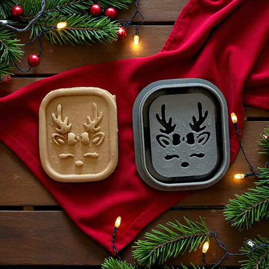 Reindeer cutter and clay piece on red napkin surrounded by string lights