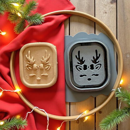 Reindeer clay cutter and clay imprint displayed on wooden board with red fabric