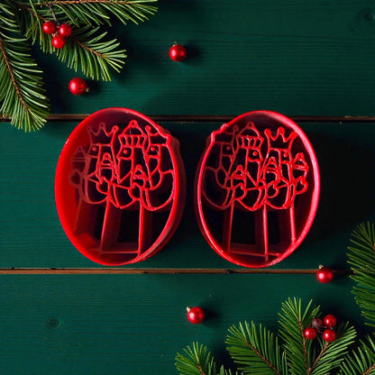 Pair of red Three Kings clay cutters on green background with Christmas accents