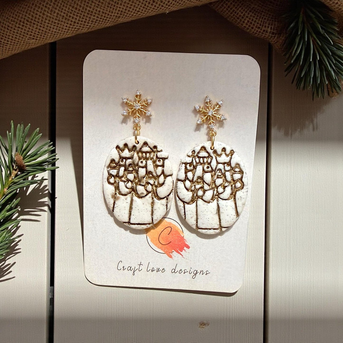 Three Kings polymer clay earrings on display card with gold snowflake studs
