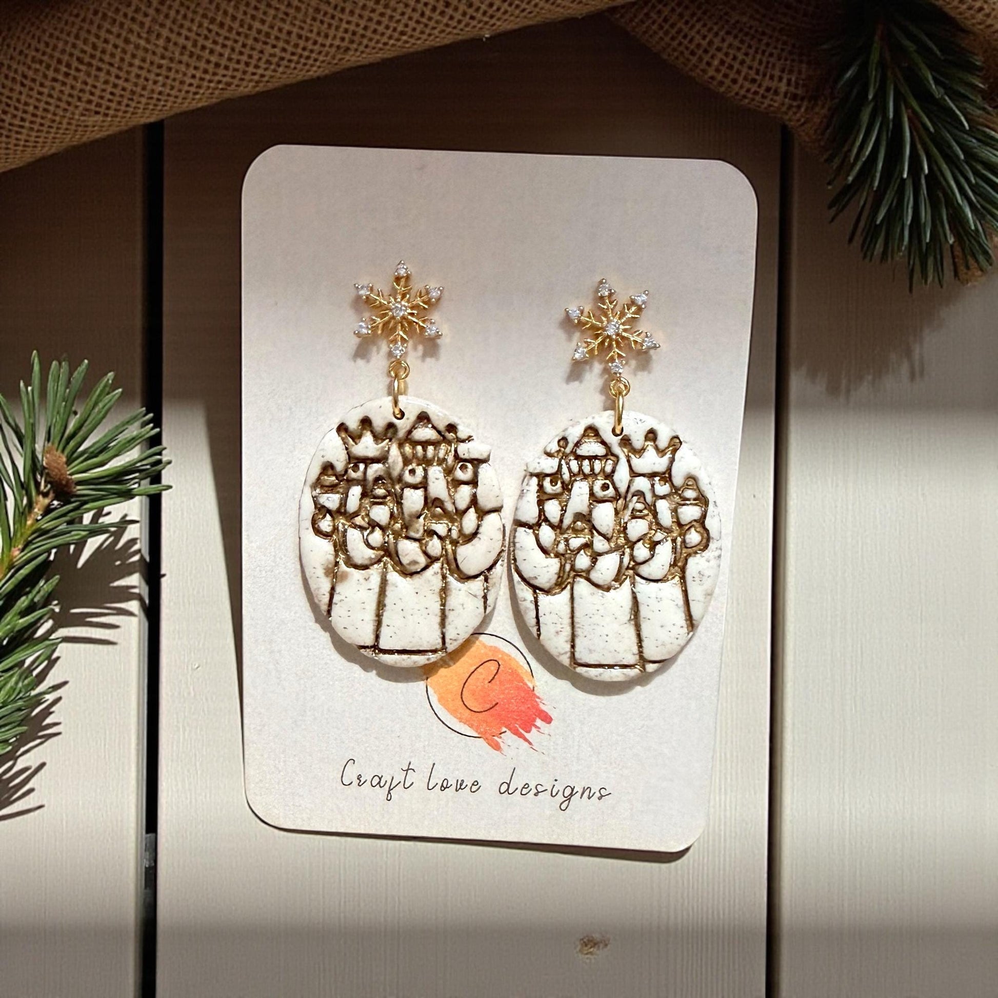 Three Kings polymer clay earrings on display card with gold snowflake studs