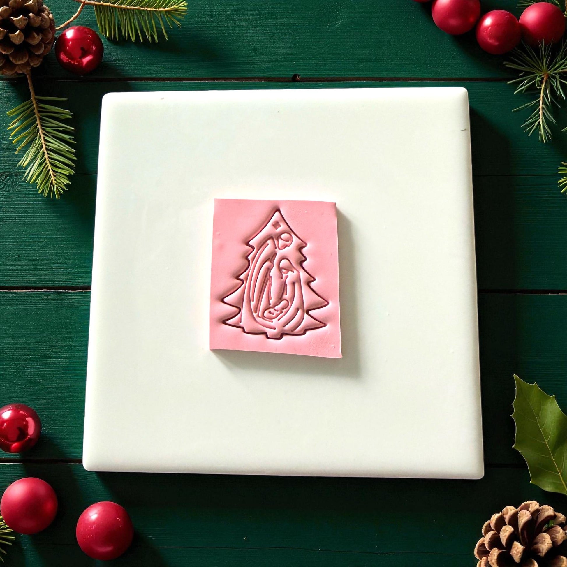 Pink nativity tree clay imprint on square clay slab with festive ornaments