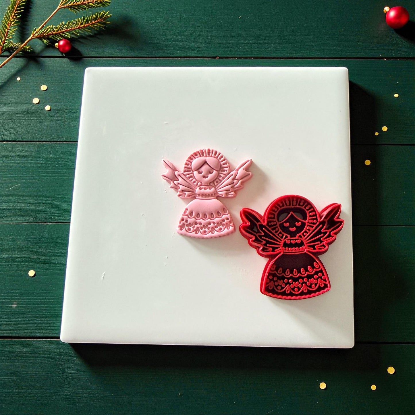 Pink and red angel cutters side by side on white tile