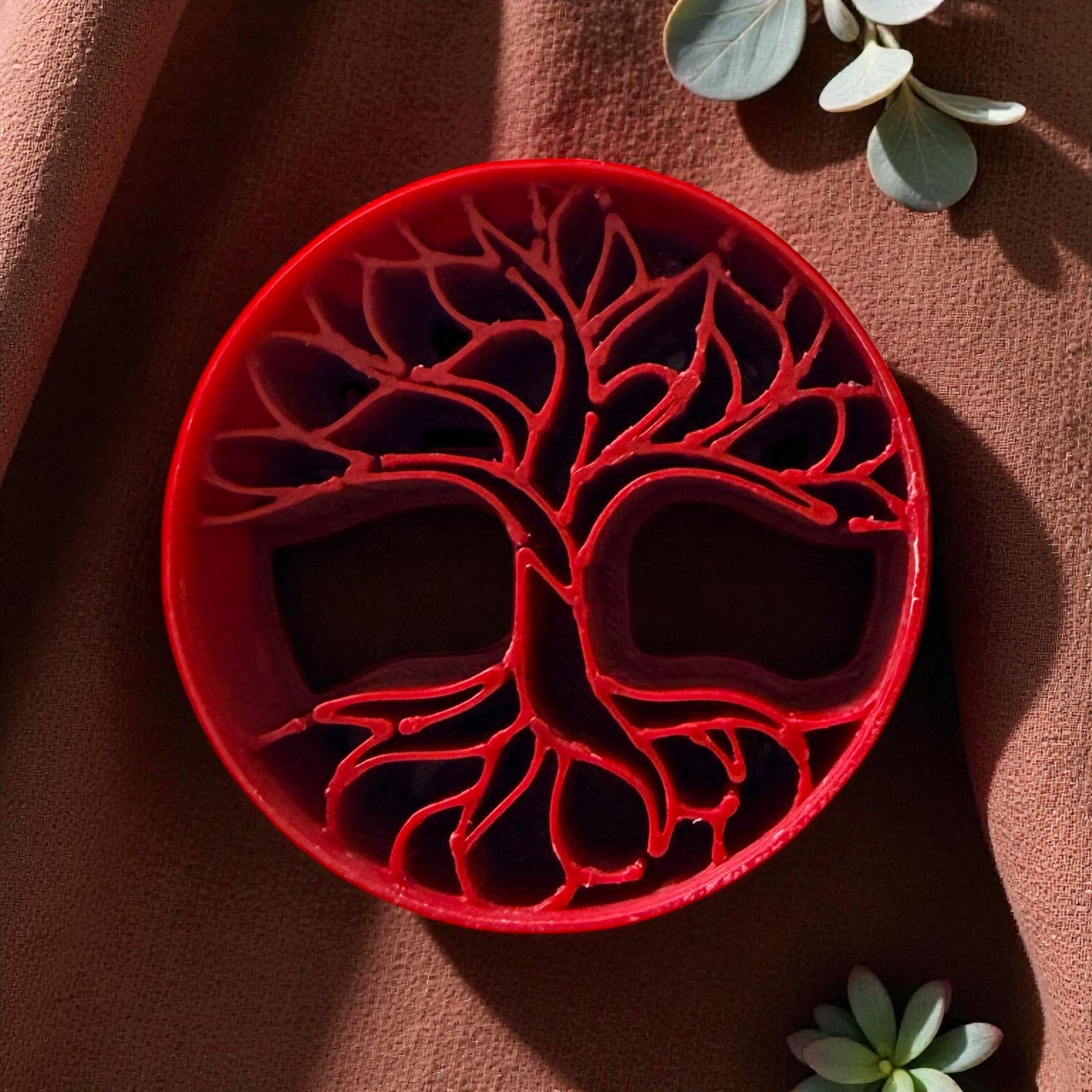 Round tree of life clay cutter displayed on white tile with soft lighting