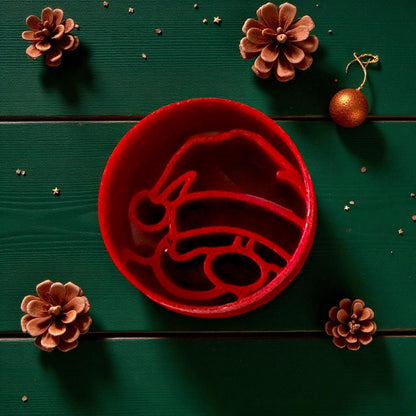 Close-up of red Santa cutter surrounded by pinecones and gold ornaments