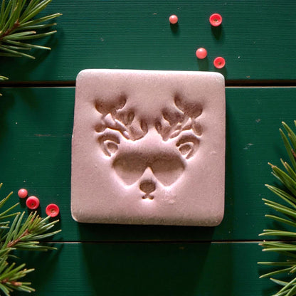 Close-up of reindeer imprint showing heart-shaped sunglasses and antlers