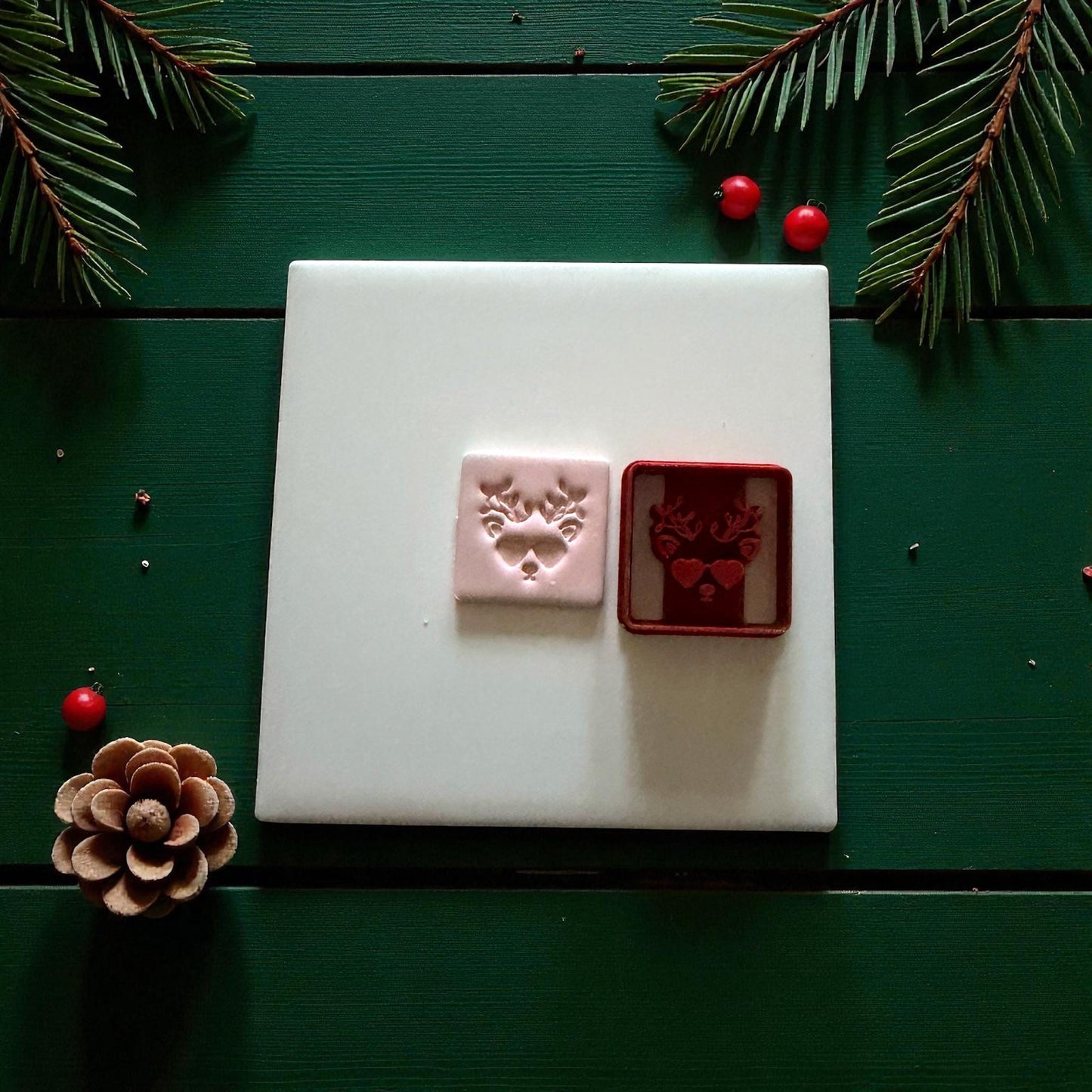 Pink and red reindeer cutters side by side on white tile with holiday decor