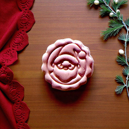 Close-up of pink Santa imprint with scalloped edges and pine branches