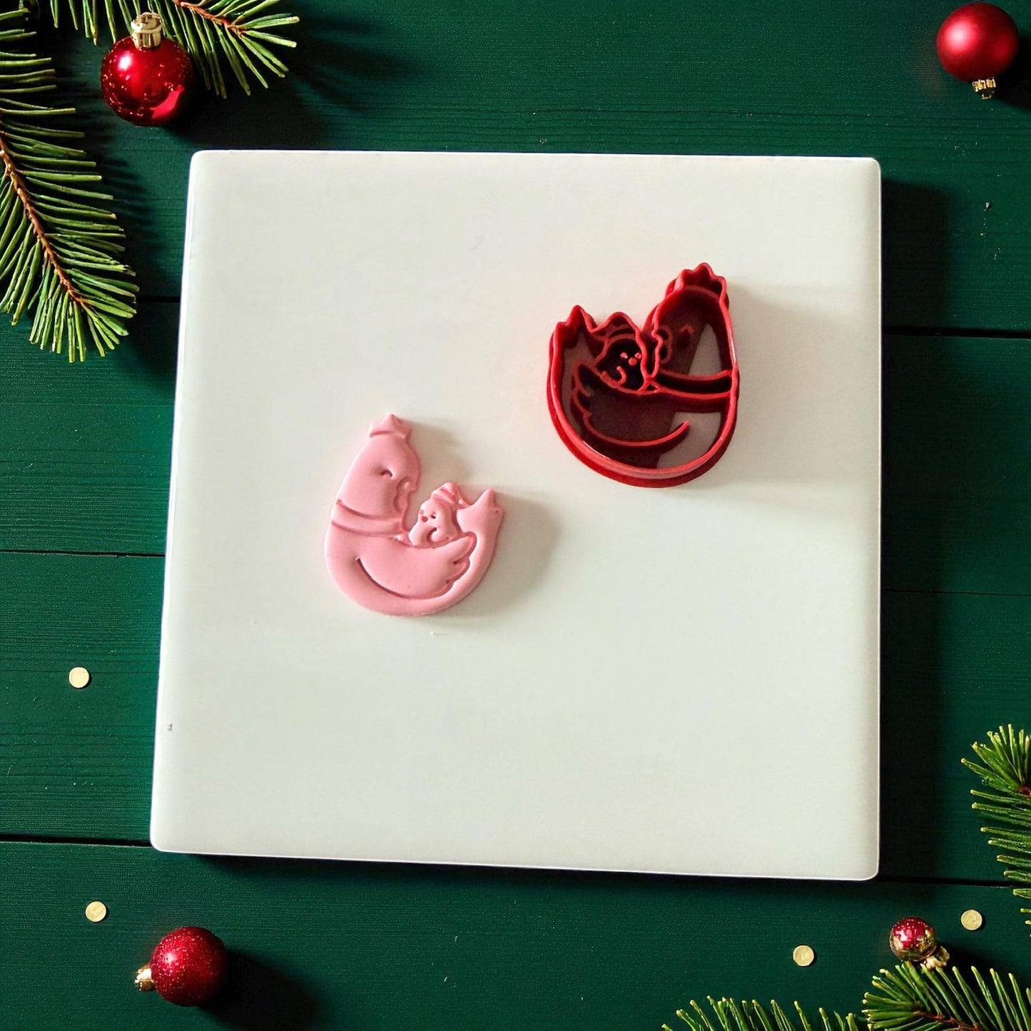 Chicken and chick cutter with clay piece on white tile and pine accents