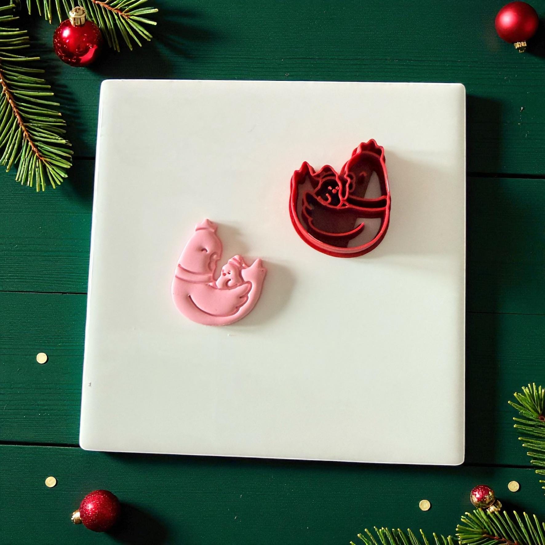 Chicken and chick cutter with clay piece on white tile and pine accents