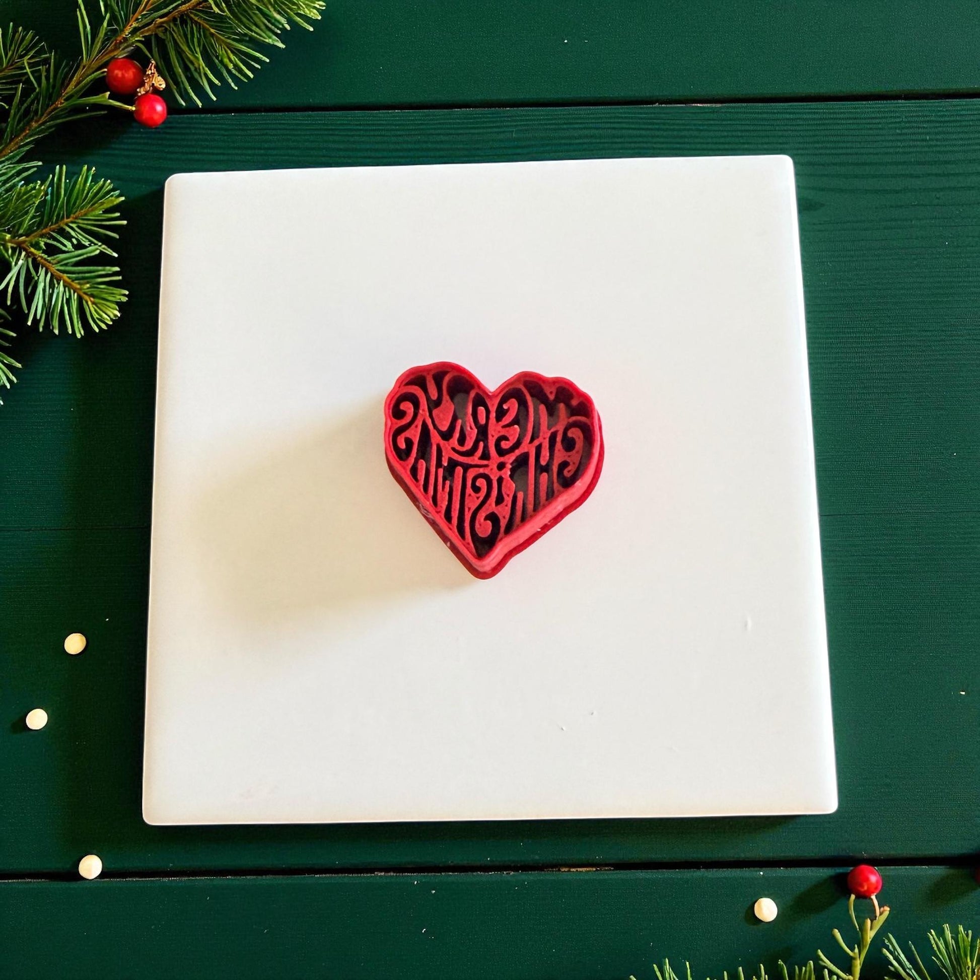 Red Merry Christmas heart cutter displayed on white tile