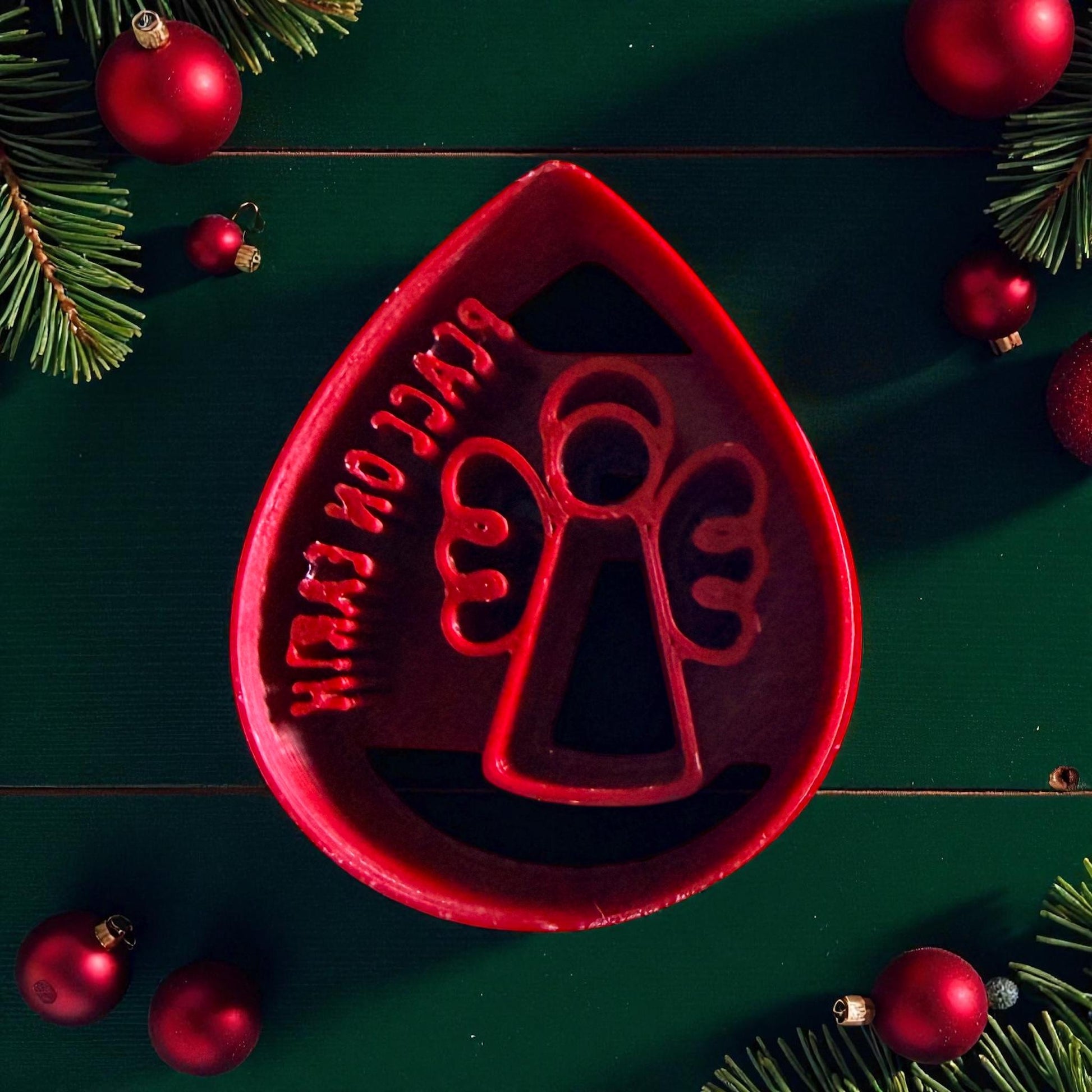 Close-up of red angel clay cutter and pink embossed clay teardrop