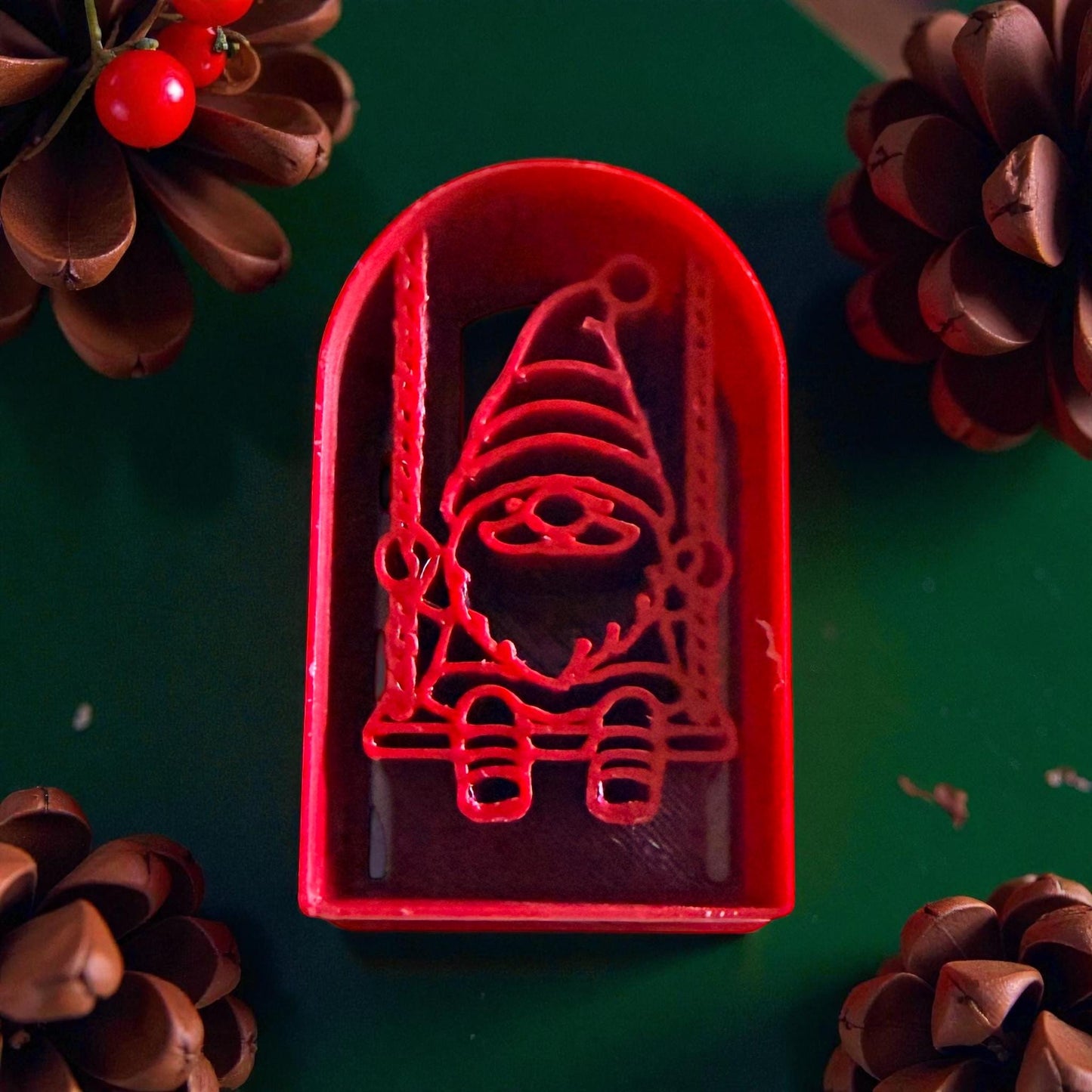 Close-up of red gnome swing cutter with pinecones and red accents
