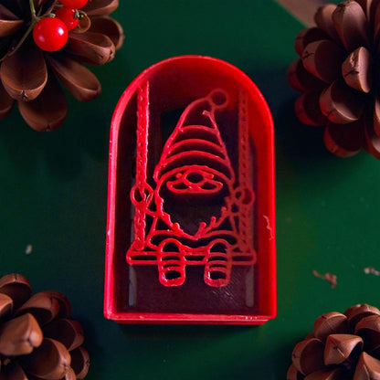 Close-up of red gnome swing cutter with pinecones and red accents