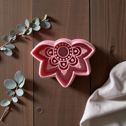 Pink boho lotus polymer clay cutter on wooden surface with eucalyptus