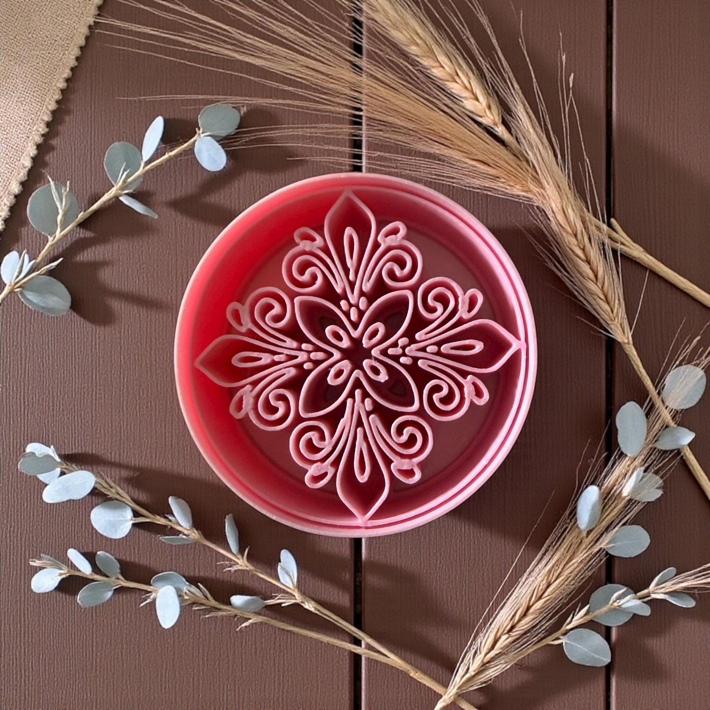 Pink round floral polymer clay cutter with boho medallion pattern and dried wheat stems