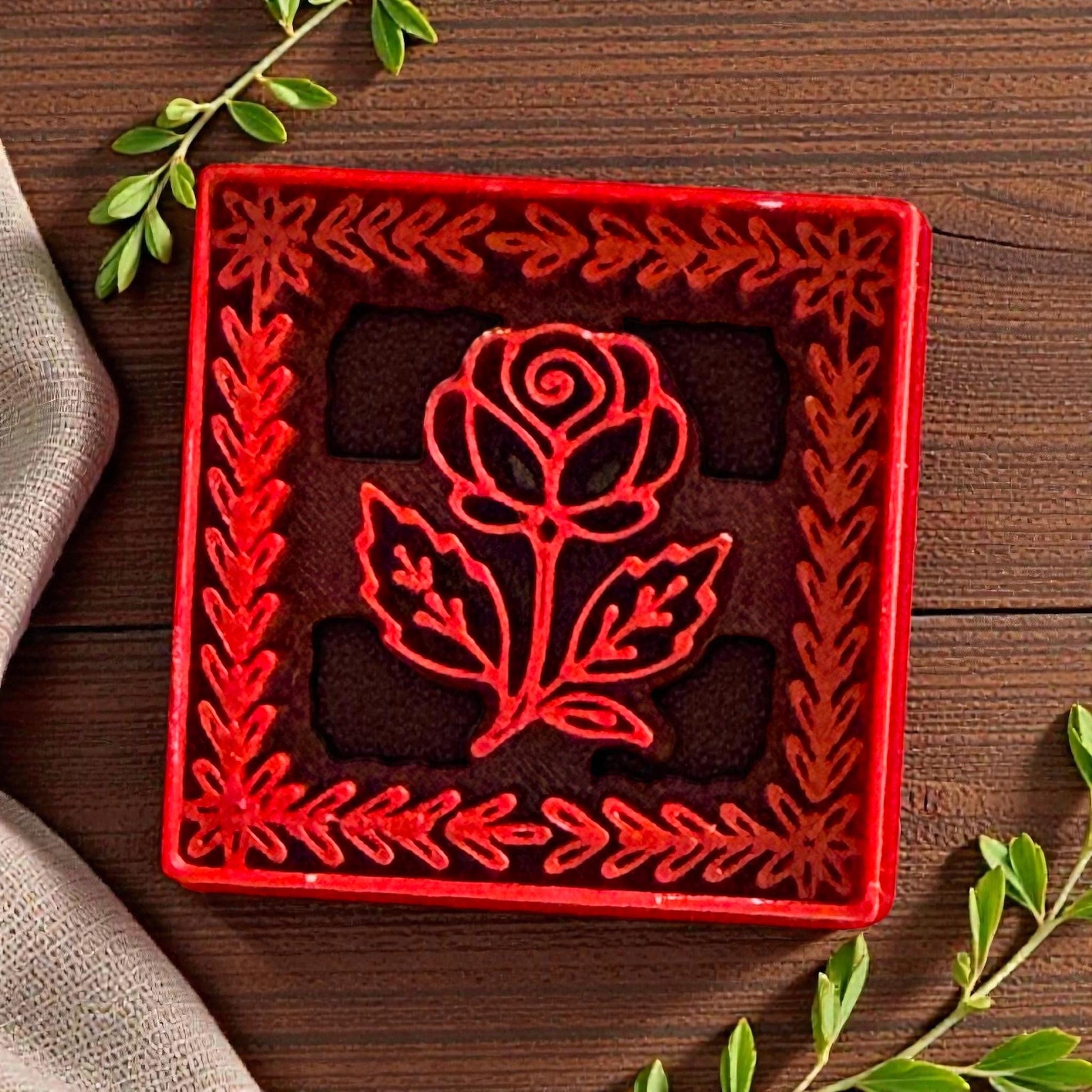 Close-up of red rose frame clay cutter showing detailed floral border and leaf design