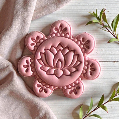 Pink lotus clay impression surrounded by soft fabric and greenery
