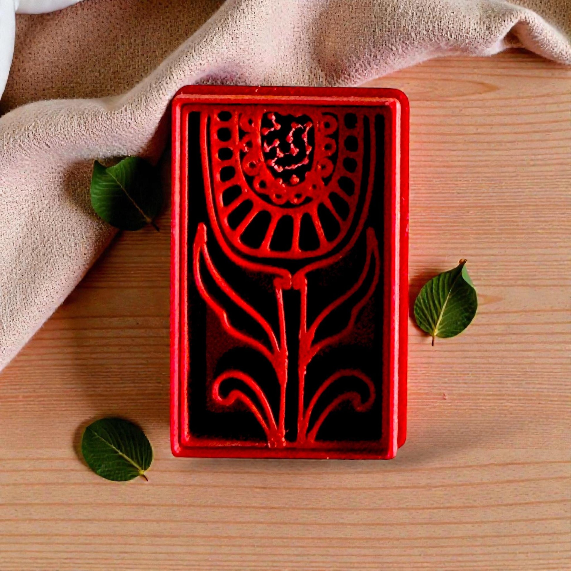 Red folk tulip polymer clay cutter on fabric with leaves and neutral background