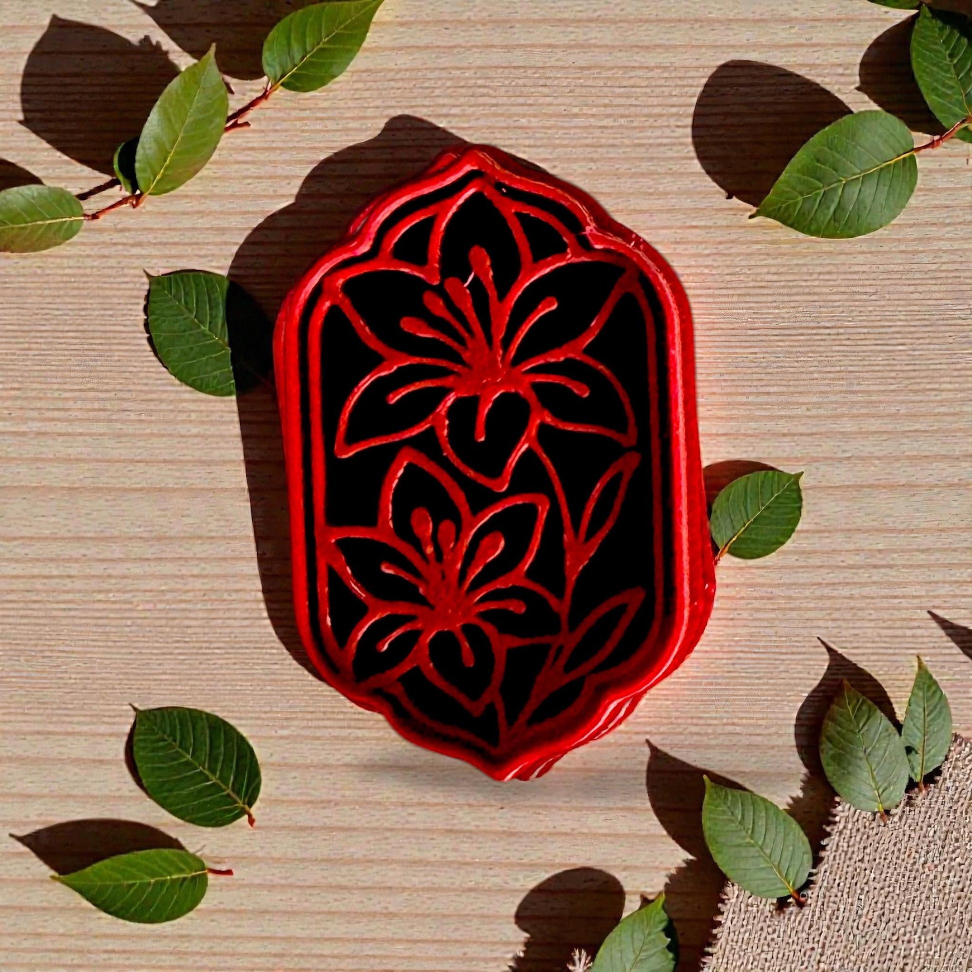 Red floral frame polymer clay cutter with two lilies on wood and greenery