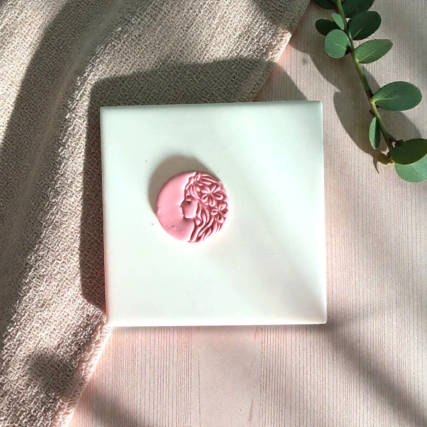 Pink floral goddess clay impression centered on white tile
