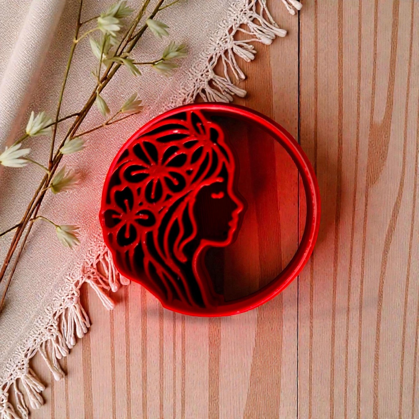 Red floral woman profile polymer clay cutter on wood with linen and flowers