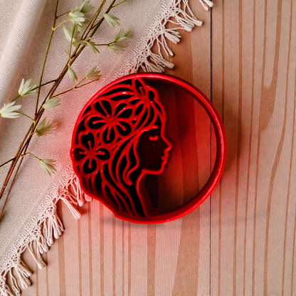 Red floral woman profile polymer clay cutter on wood with linen and flowers