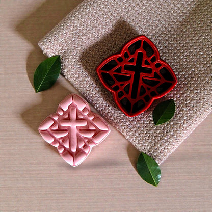 red cross cutter next to pink clay impression