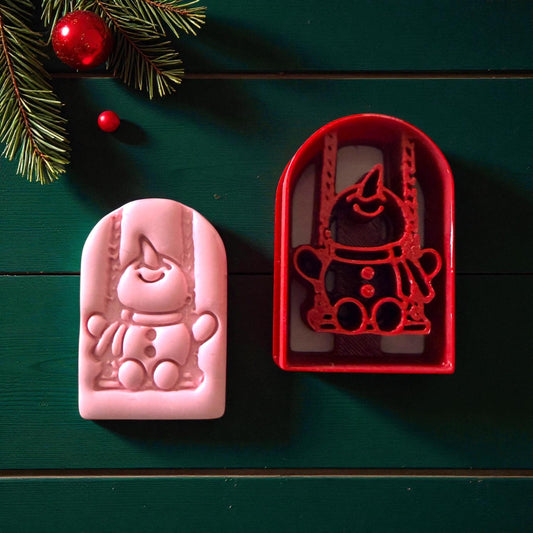 Pink and red snowman swing cutter side by side on green background