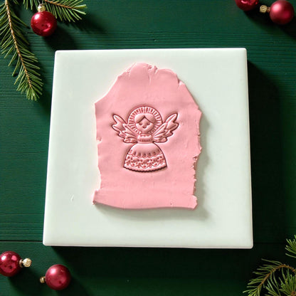 Pink angel clay imprint pressed into slab on white tile