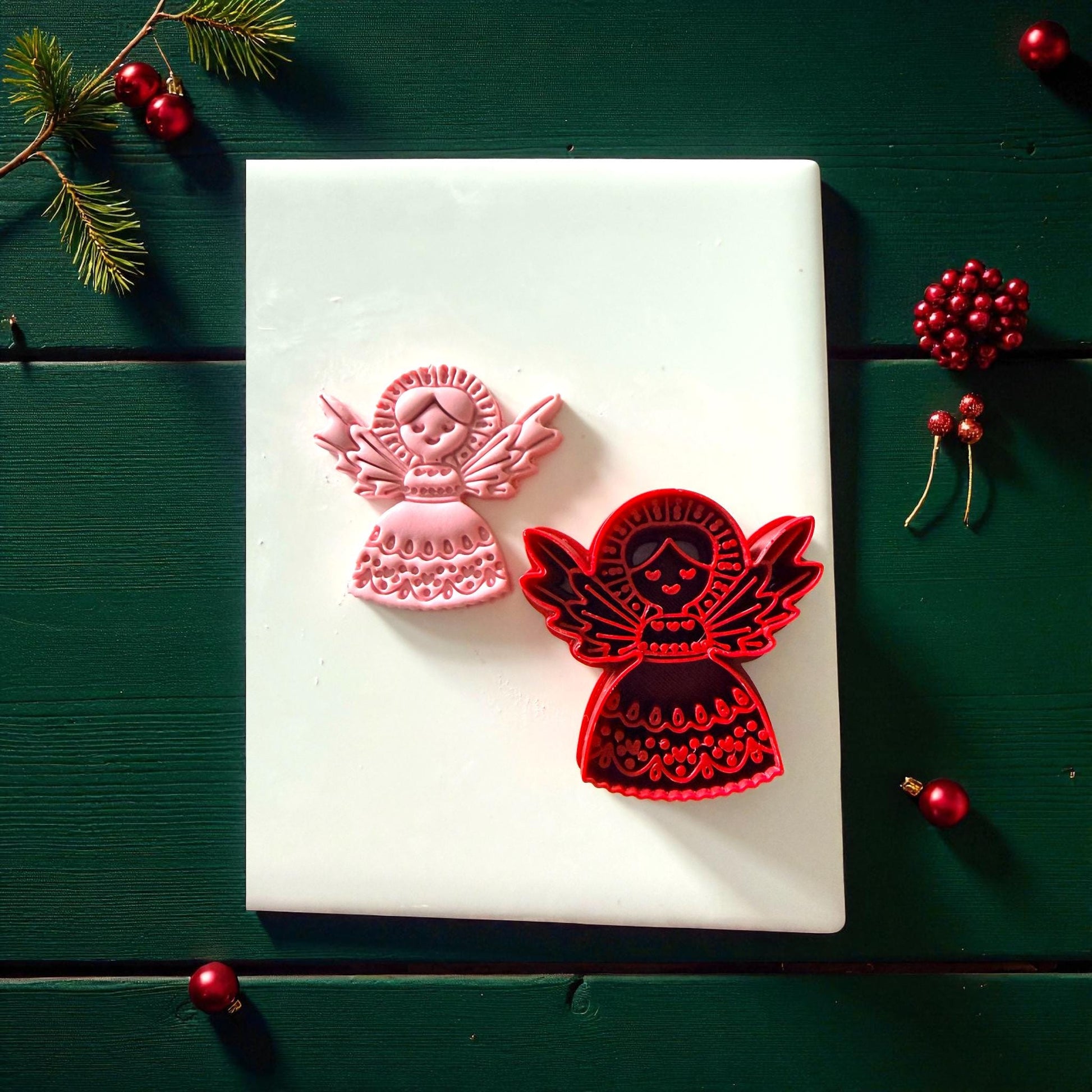 Pink and red angel cutters side by side on white tile