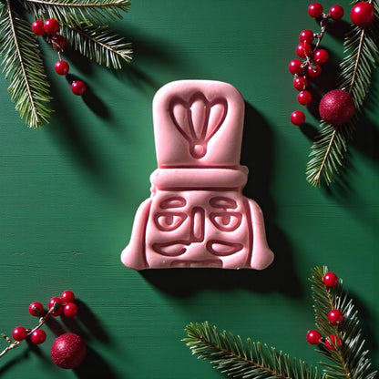 Close-up of pink nutcracker clay imprint with festive greenery