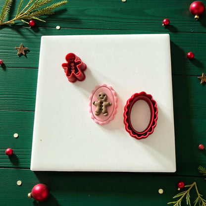 Flat lay of gingerbread cameo clay piece and cutters surrounded by ornaments