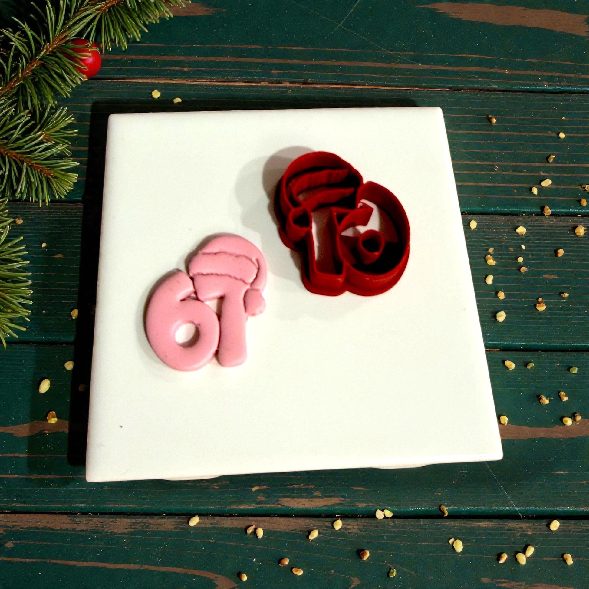 red santa hat 67 cutter beside pink impression on green surface