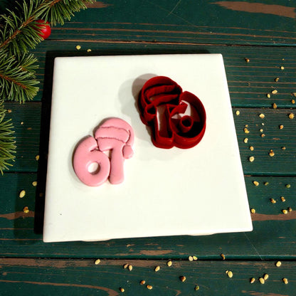 red santa hat 67 cutter beside pink impression on green surface