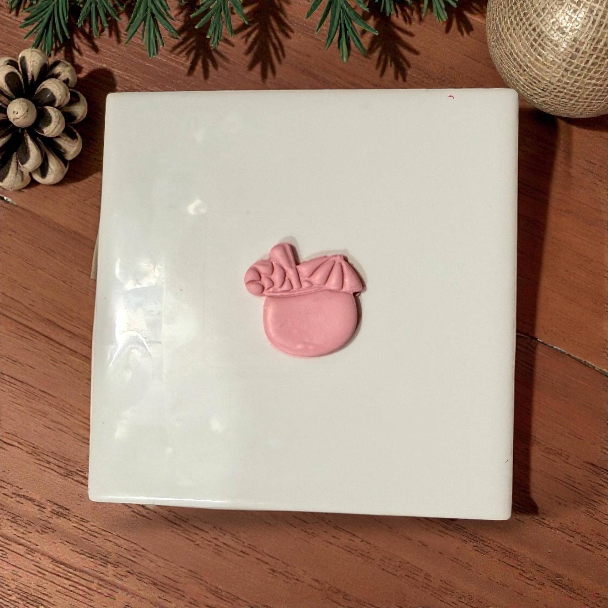 pink clay coconut drink centered on white tile