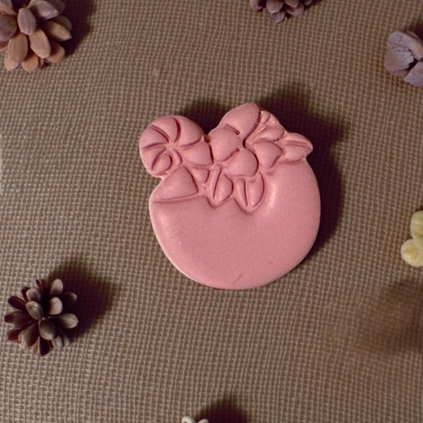 clay drink shape surrounded by mini pinecones