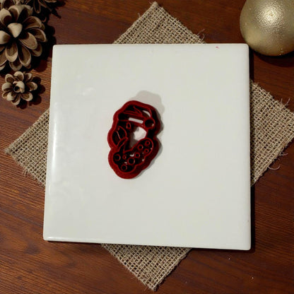 Flamingo Christmas cutter displayed on white tile with rustic burlap