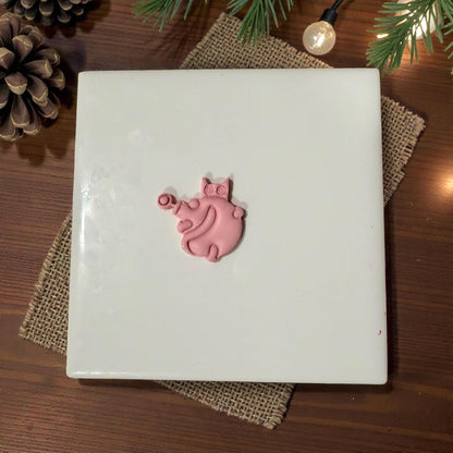small cat ornament clay piece centered on tile